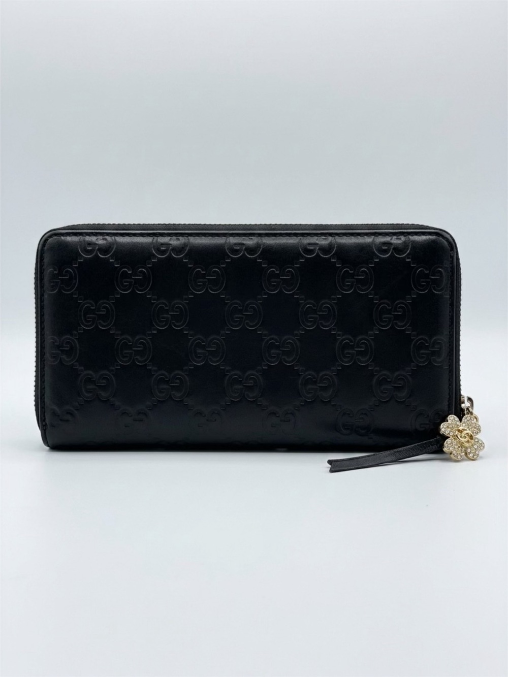 Gucci Black Leather Zip Wallet with an added zipperpull Gold Floral Gucci Charm